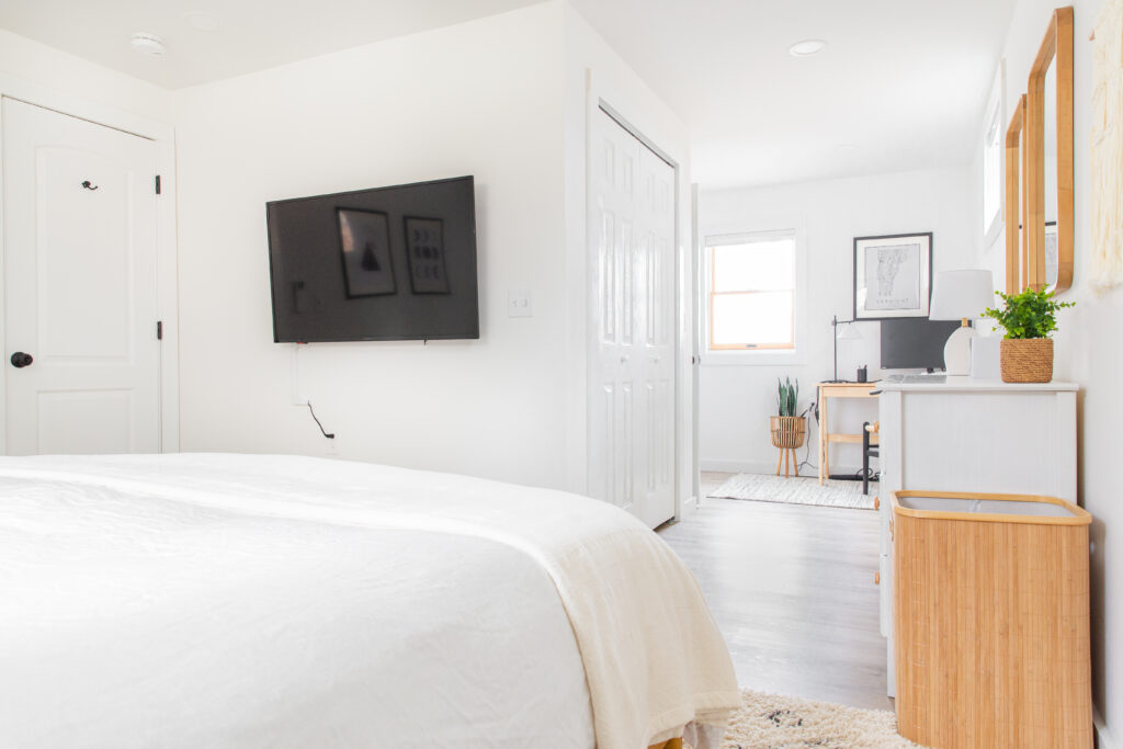 neutral bedroom with king bed, tv and dedicated workspace