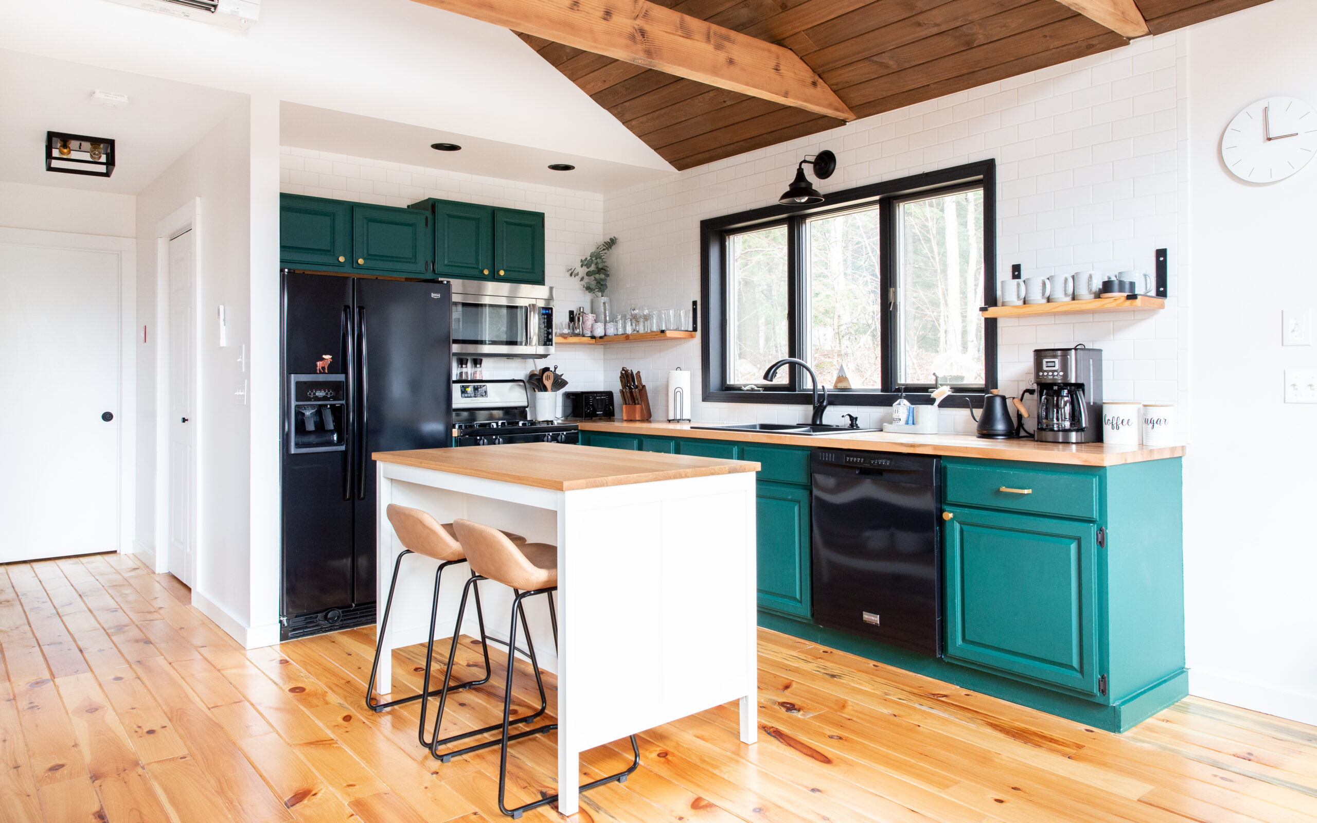 open concept kitchen with green cabinets and white island