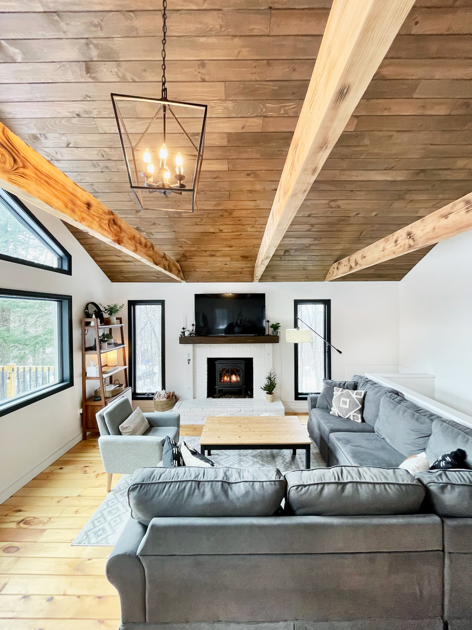 modern cabin living room with exposed beams and fireplace