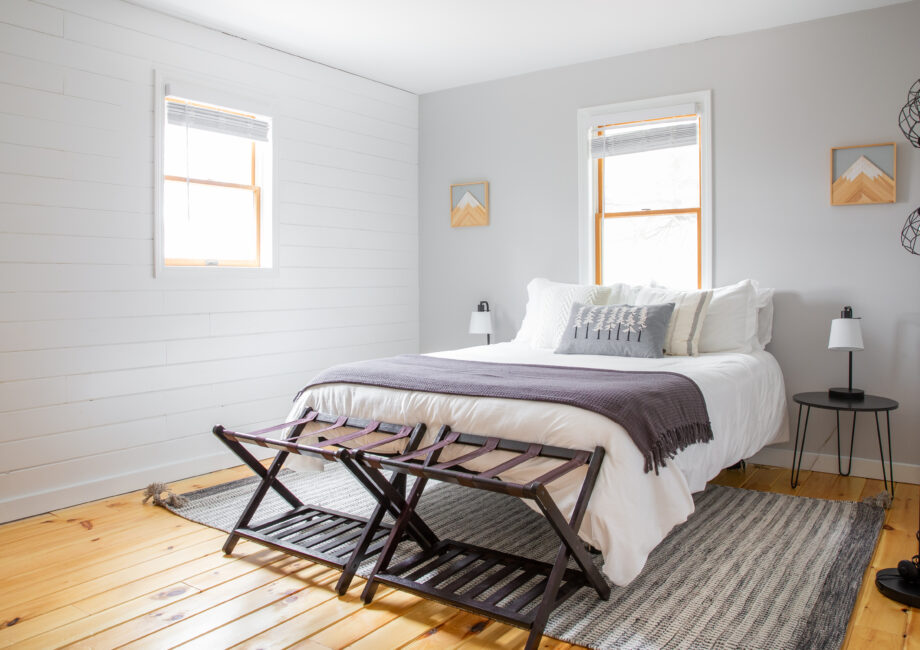 light and airy bedroom with light blue walls, wood floor and grey accents
